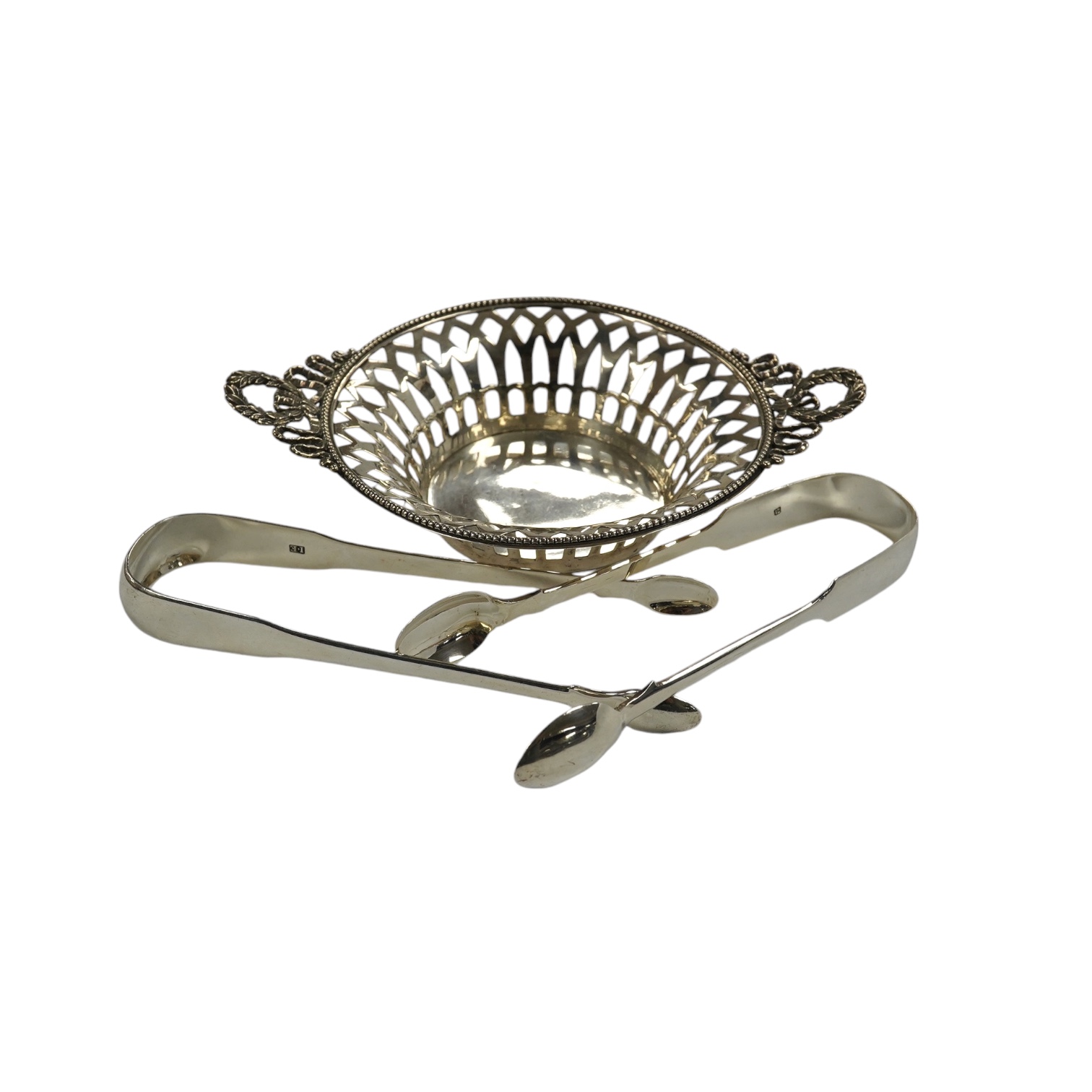 Two pairs of 19th century silver sugar tongs, including London, 1803 and a silver bonbon dish. Condition - fair to good